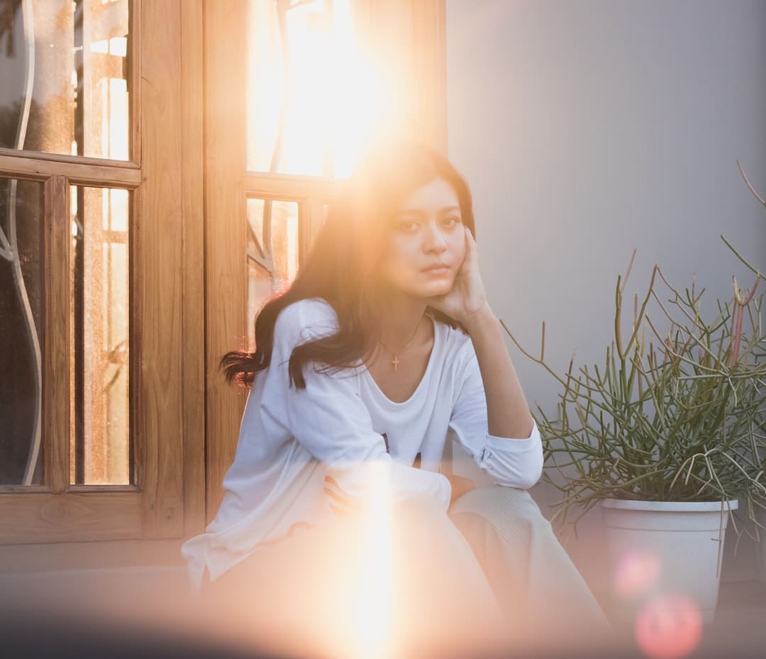 Thoughtful Latina woman by a sunlit window